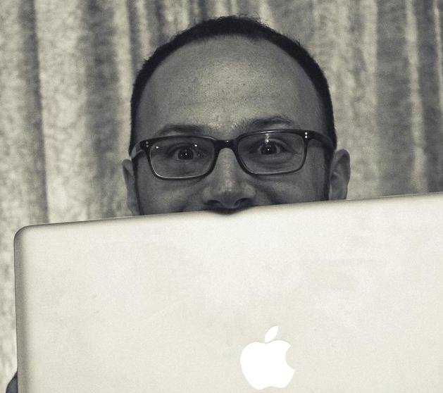 sital playfully posing with face half covered by laptop